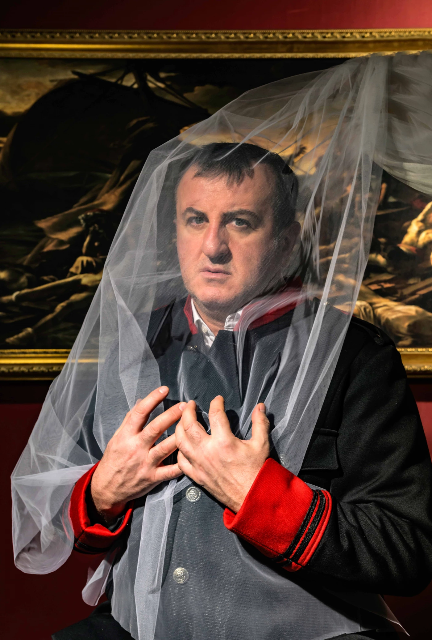 Otello hält beide Hände über seinen Brustkorbn und hat einen transparenten Vorhang über sich. | © Theater Bonn