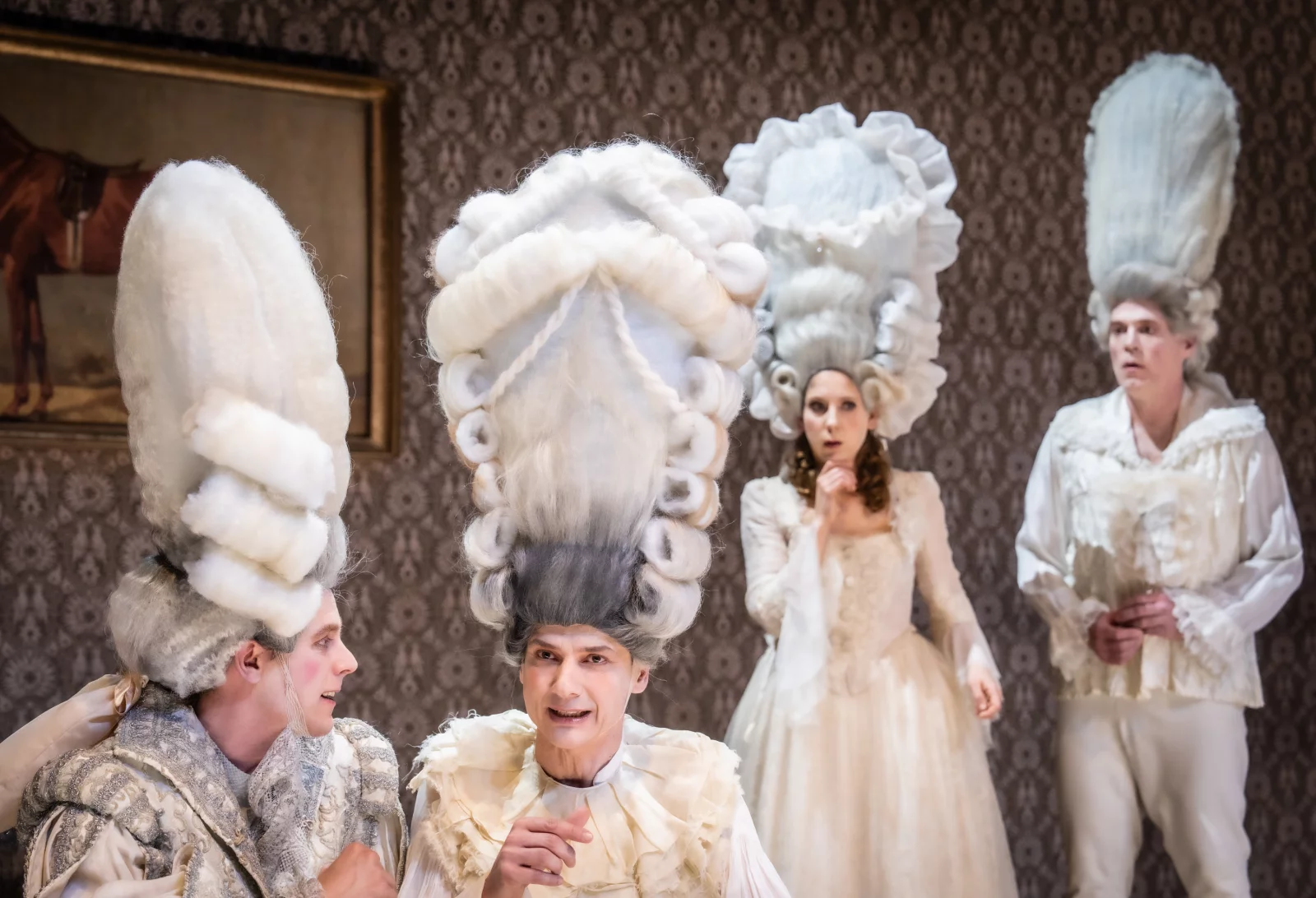 Vier Schauspielende tragen hohe barocke Perrücken. Zwei Personen unterhalten sich angeregt. | © Matthias Jung